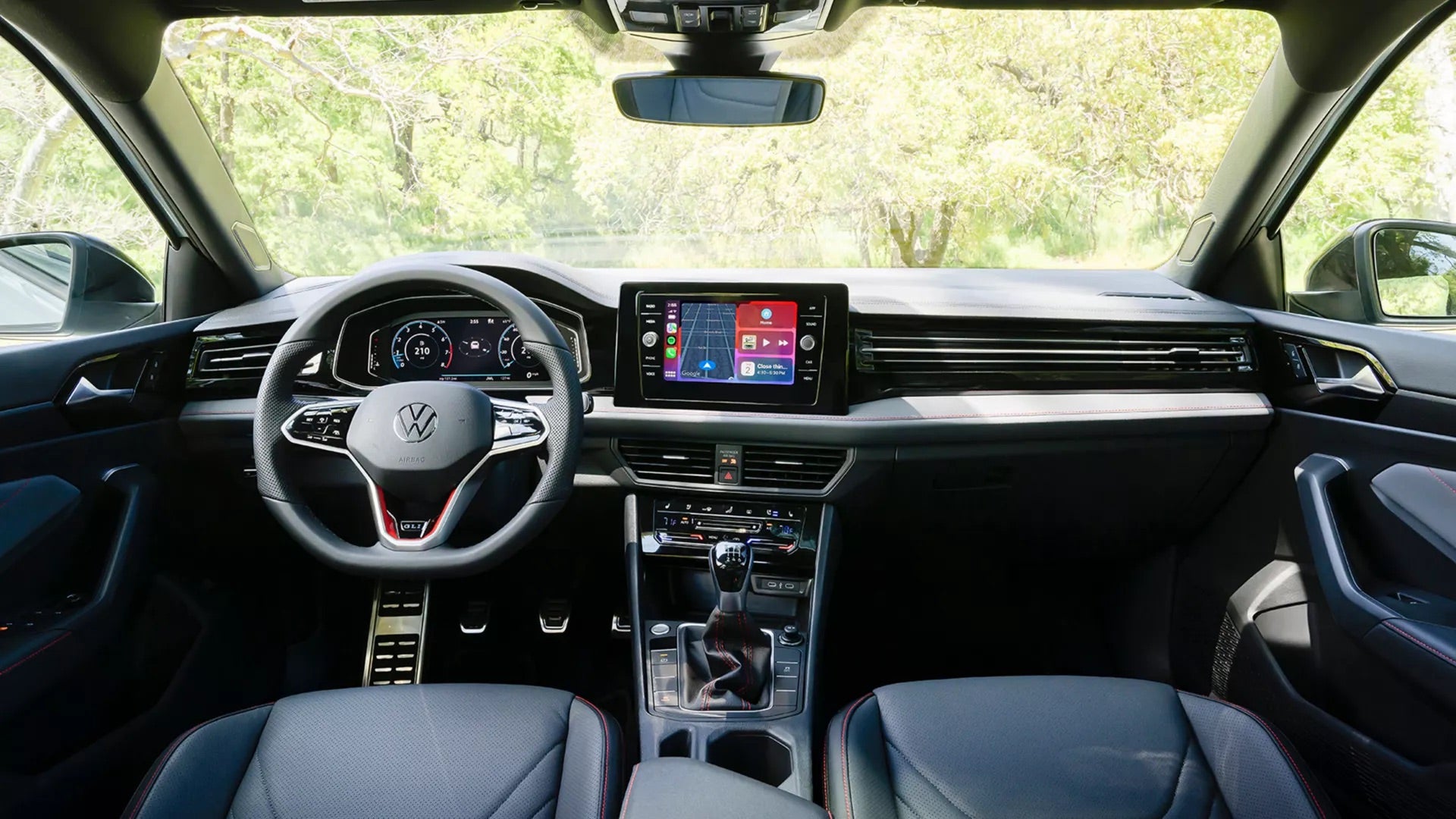 2026 Volkswagen Jetta GLI full dashboard interior showing flat-bottom sport steering wheel, 10-inch touchscreen, and GLI sport seats